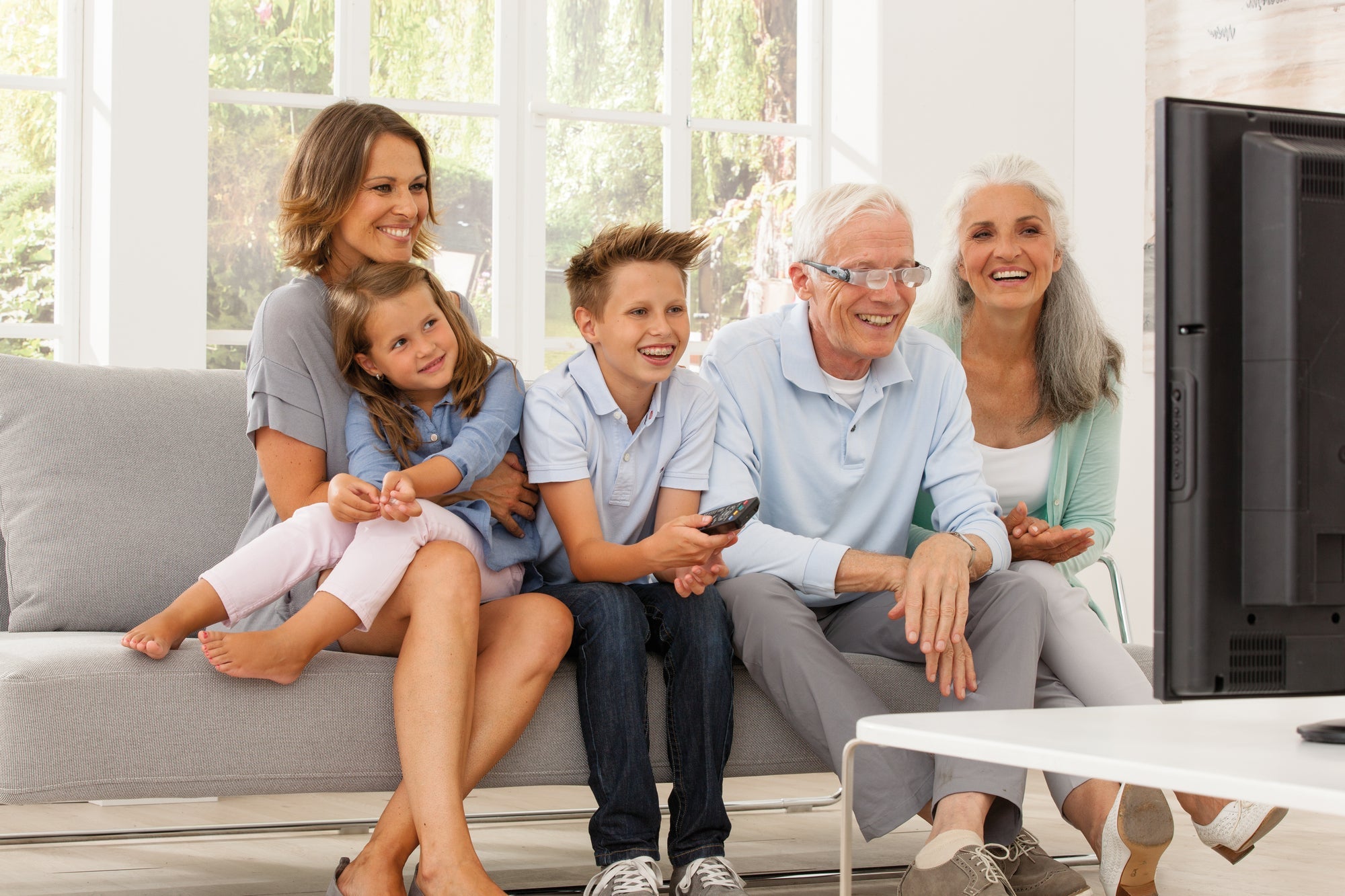 Man watching TV with MaxTV and his family 