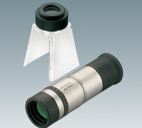 Handheld monocular with silver colour coating and black eyepiece, next to stand with eyepiece for converting monocular to stand magnifier or stand microscope